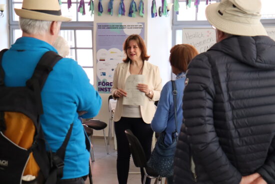 Anne-Marie Springmann, Mitarbeitende der HfGG, gibt Besucher:innen eine Hausführung des Campus